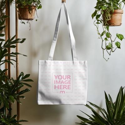Canvas Tote Bag Mockup Hanging on a Background with Leaves