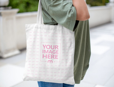 Mockup of a Tote Bag on The Shoulder of a Woman Wearing Her Green Shirt